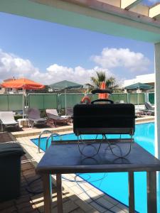 a table sitting next to a swimming pool at SHINE VERANDA PRIVE APTS 7PERSONS in Plataniás