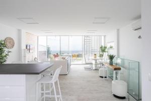 a white kitchen with white chairs and a table at Nerja Luxury Apartment in Nerja