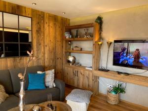 a living room with a couch and a flat screen tv at Alpine Lodge by Apartment Managers in Kirchberg in Tirol
