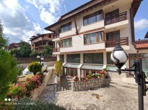 um edifício com flores e uma luz de rua em frente em Guest House Ela em Bansko