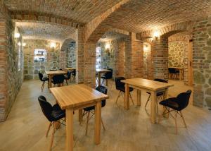 a room with wooden tables and chairs and brick walls at Dom Krawca - pod Chojnikiem in Jelenia Góra