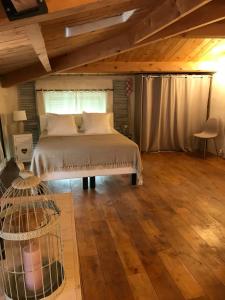 Schlafzimmer mit einem Bett und Holzboden in der Unterkunft La Charmeuse in Céreste