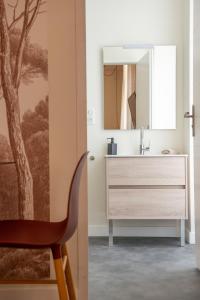 a bathroom with a chair next to a sink at La Maison des Vendangeurs en Ville in Narbonne