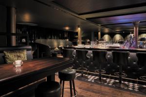 a bar with black leather seats and a wooden table at TORTUE Hamburg in Hamburg