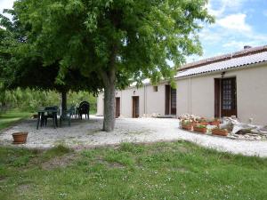 una casa con una mesa y un árbol en un patio en Au Jardin près de l'ocean, en Les Mathes