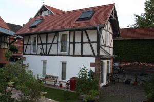 una casa blanca y negra con techo rojo en Ferienhaus Alte Schmiede, en Kirchhain