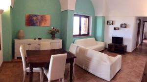 una sala da pranzo con tavolo e sedie bianche di Il dammuso di Giorgia a Pantelleria