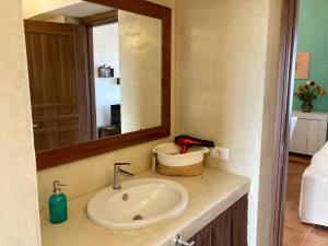 a bathroom with a sink with a mirror and a mirror at Il dammuso di Giorgia in Pantelleria +16 photos
