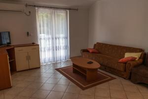 ein Wohnzimmer mit einem Sofa und einem Couchtisch in der Unterkunft Apartment in Mundanije with balcony, air conditioning, WiFi (4912-1) in Mundanije