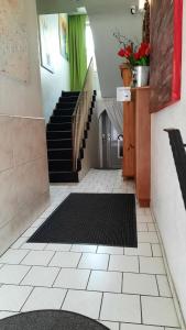 a hallway with a staircase with a black rug at Hotel Merlin Garni in Cologne