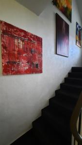 een trap met een rood schilderij aan de muur bij Hotel Merlin Garni in Keulen