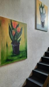 een schilderij van een pot bloemen op een muur bij Hotel Merlin Garni in Keulen