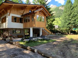 a house in the mountains with a patio at Chalet degli Abeti by AMA Val di Fassa in Campitello di Fassa