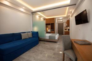 a living room with a blue couch and a bedroom at 4- you Family in Metamorfosi