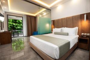 a bedroom with a large bed and a balcony at 4- you Family in Metamorfosi