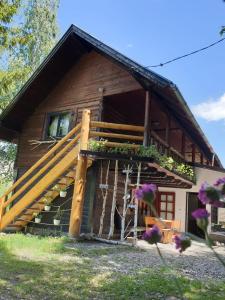 a log cabin with a staircase in front of it at Pensiunea Padina in Bran