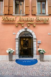 einen Hoteleingang mit einem Schild an einem Gebäude in der Unterkunft Hotel Antico Borgo in Riva del Garda