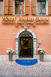 a hotel entrance with a sign on a building at Hotel Antico Borgo in Riva del Garda