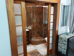 a shower with a glass door in a bathroom at Le Chateau Guest House and Conference Centre in Kempton Park +57 photos