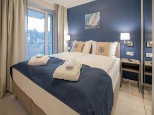 - une chambre avec un grand lit et des serviettes dans l'établissement Dünenresidenz Prora - Ferienwohnung in Toplage mit Meerblick, Balkon und Sauna NP-221, à Binz