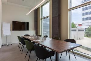 einen Konferenzraum mit einem großen Tisch und Stühlen in der Unterkunft Centurion Swiss Quality Towerhotel Windisch in Brugg