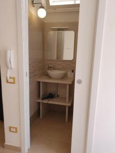 a bathroom with a sink and a mirror at Loft Ionios in Noto Marina +2 photos
