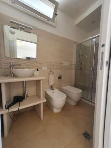 ein Bad mit einem Waschbecken, einem WC und einer Dusche in der Unterkunft Loft Ionios in Noto Marina