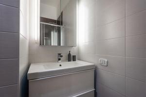 a white bathroom with a sink and a mirror at Casa Anna in Riva del Garda +27 photos