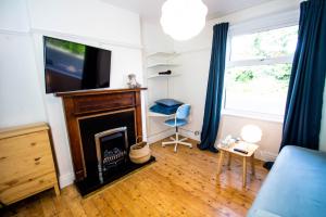 a living room with a fireplace and a flat screen tv at Peaceful House in the Centre of City in Lancaster