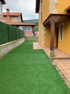 un jardin avec de l'herbe verte sur le côté d'une maison dans l'établissement Chalet Individual en Vargas, Cantabria, à Vargas