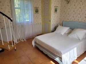 een slaapkamer met een bed en een raam bij La Marviniere in Saint-Bonnet-sur-Gironde