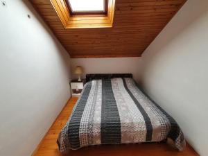 Bett in einem Zimmer mit Holzdecke in der Unterkunft Green Garden NAT in Koper