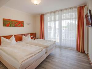 ein Hotelzimmer mit zwei Betten und einem großen Fenster in der Unterkunft Strandvillen Binz - Ferienwohnung mit Meerblick, 2 Schlafzimmern und Balkon SV-761 in Binz