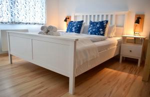 a white bed with blue pillows in a bedroom at Gosau Apartment 209 in Gosau