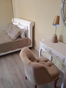 een slaapkamer met een bed, een stoel en een tafel bij Paralion Town Apartments in Alexandroupoli