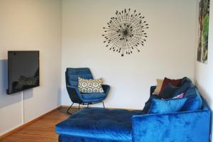 sala de estar con sofá azul y silla en Obst- & Ferienhof Rauscher, en Friedrichshafen