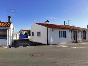 a street with two white buildings and a street light at Maison cosy à La Tranche-sur-Mer - 45 m² avec jardin in La Tranche-sur-Mer