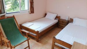 een kleine kamer met 2 bedden en een stoel bij Gythio Seaside Villa Dimitrios - Panoramic View in Gythio