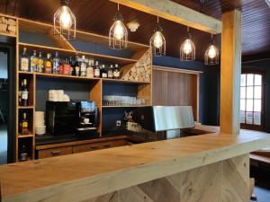 a bar with a wooden counter and pendant lights at Hotel Restaurant Jungfrau in Lauterbrunnen
