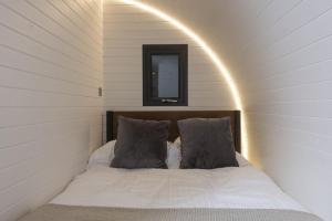 a bed with two pillows in a room with a mirror at Harbour Hideaway in Newlyn