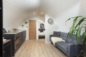 a living room with a couch and a kitchen at Harbour Hideaway in Newlyn