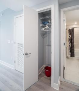 un armadio con porta bianca e uno sgabello rosso di Bluebird Suites Near Chevy Chase a Bethesda