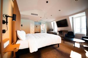 a hotel room with a large white bed and a desk at You Hotels Deauville - Handwritten Collection in Deauville