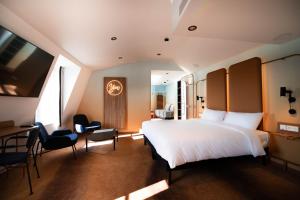 a bedroom with a bed and a desk and chairs at You Hotels Deauville - Handwritten Collection in Deauville