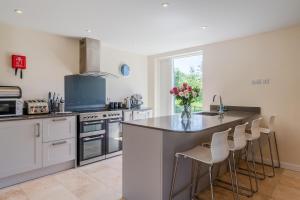 a kitchen with a counter with stools in it at Hill View Rise in Chipping Campden