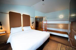 a bedroom with a large white bed in a room at You Hotels Deauville - Handwritten Collection in Deauville