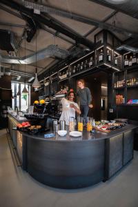 two people standing behind a counter in a kitchen at YOU Are Deauville in Deauville