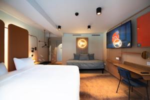 a bedroom with a bed and a desk and a television at YOU Are Deauville in Deauville