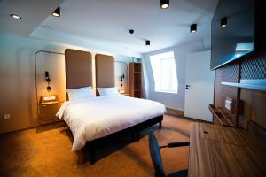 a bedroom with a large white bed and a window at YOU Are Deauville in Deauville