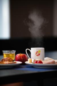a cup of tea and a plate of food with apples at You Hotels Deauville - Handwritten Collection in Deauville